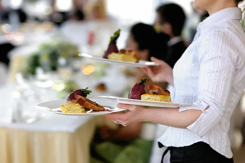 Waitress is carrying three plates