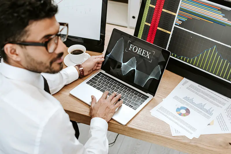 Selective focus of bi-racial trader using laptop