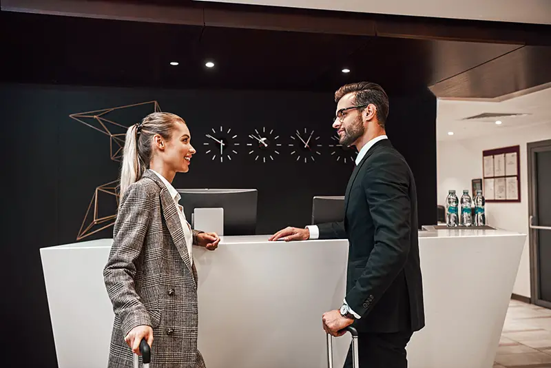 Couple on a business trip doing check-in at the hotel