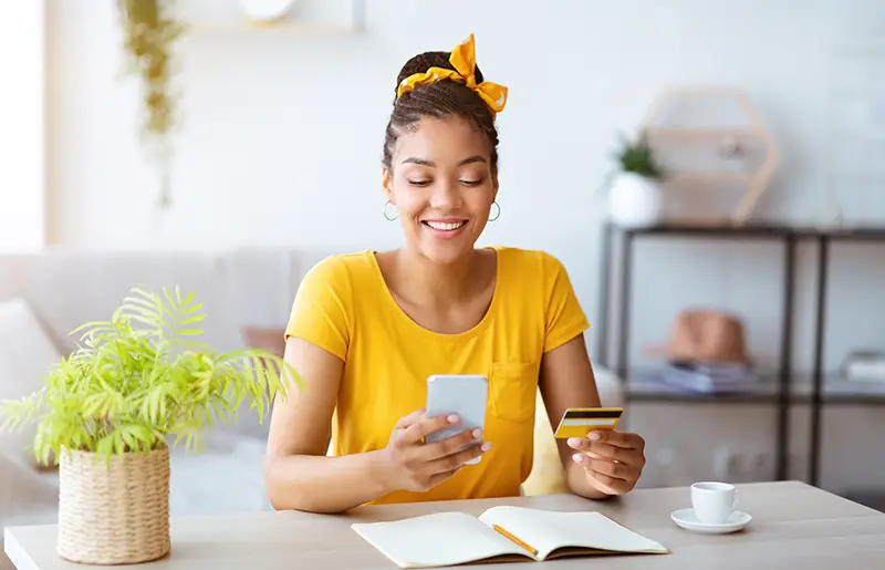 Woman Using Smartphone And Holding Credit Card used for payment