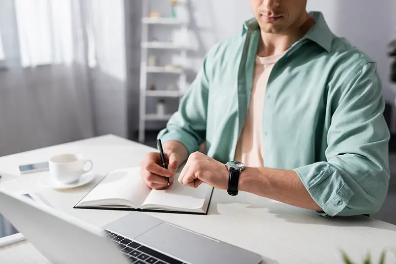 Cropped view of freelancer checking time on wristwatch