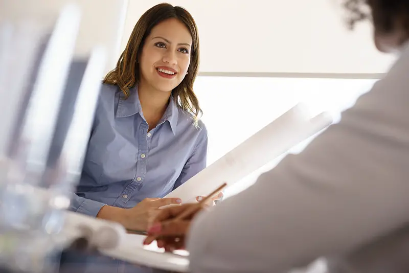 Team of two female architects, sitting at desk in office.