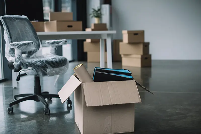 Cardboard box with folders and office supplies