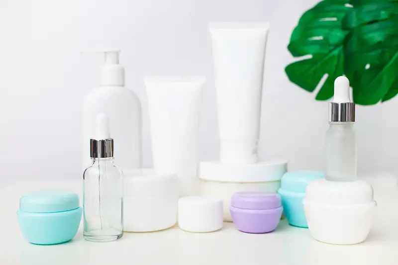 Different cosmetic bottles on white background