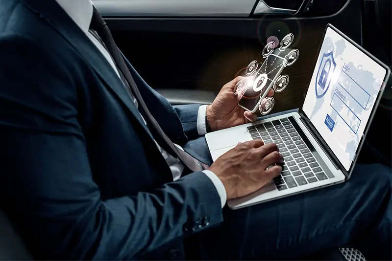 Cropped view of businessman using laptop and mobile phone