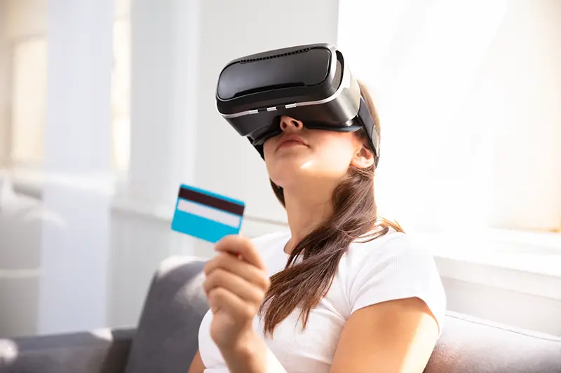 oung Woman With Credit Card Wearing Virtual Reality Glasses