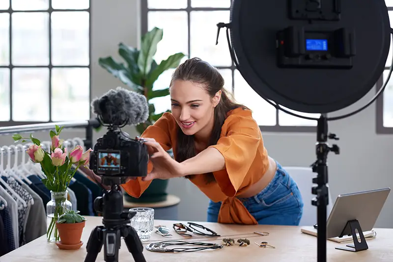 Online content creator vlogger adjusting her recording equipment