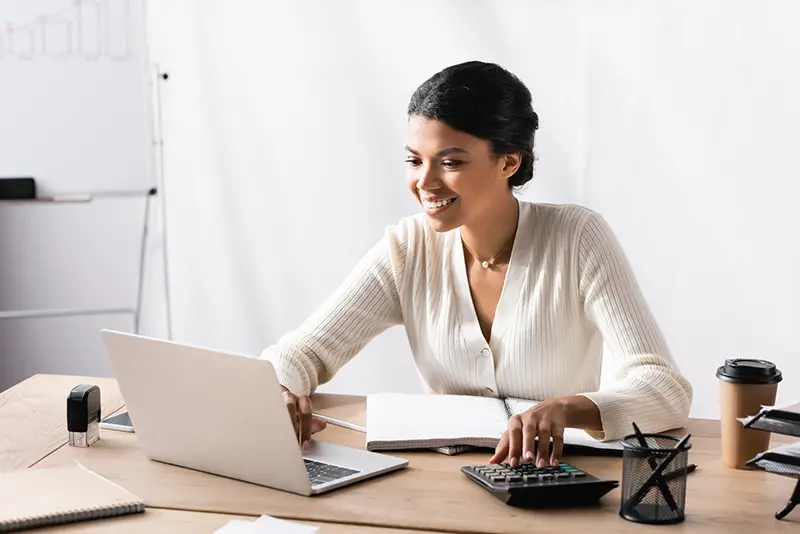 Happy african american woman looking at laptop