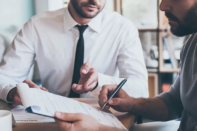 Insurance agent nad male client signing an insurance for a business