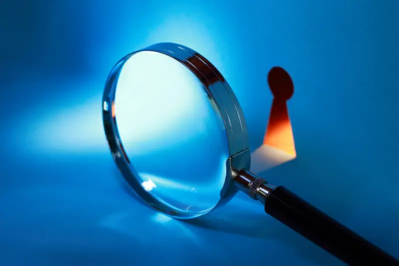 Magnifying glass near keyhole with beam of light