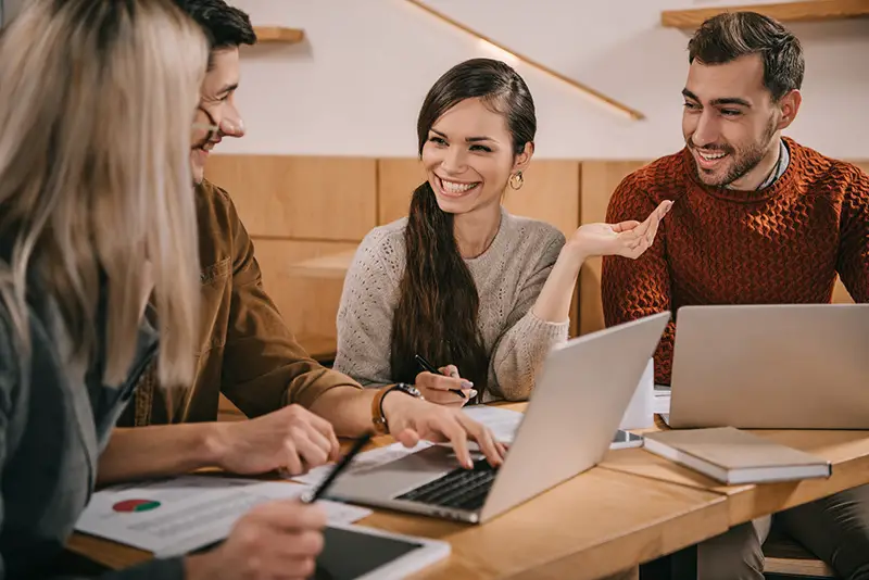 Cheerful group of coworkers talking in cafe