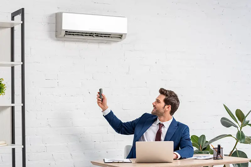 Businessman turning on the air condition inside the office