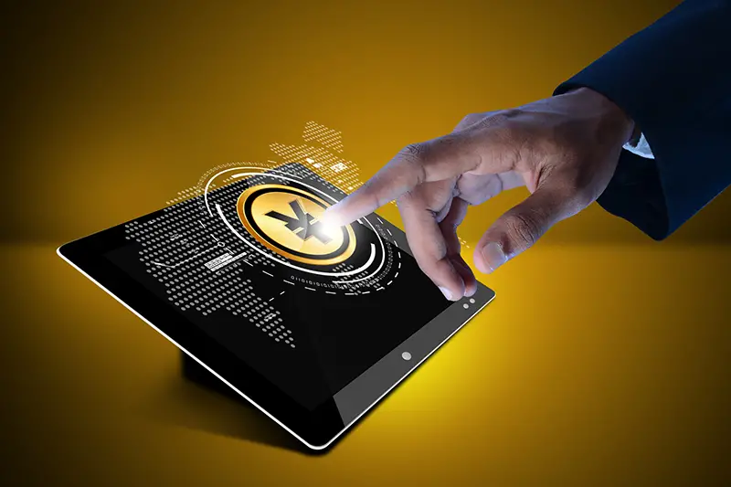 Hand pressing yuan sign in digital tablet