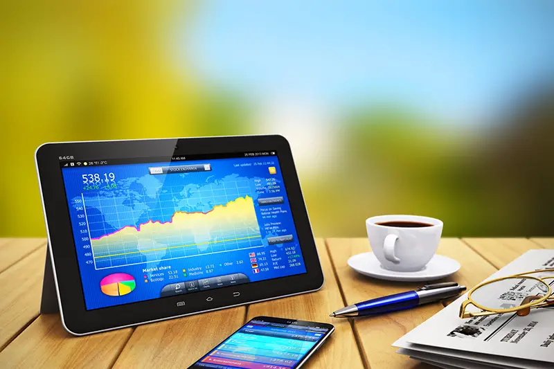 glossy tablet PC with colorful touchscreen interface of stock exchange market application