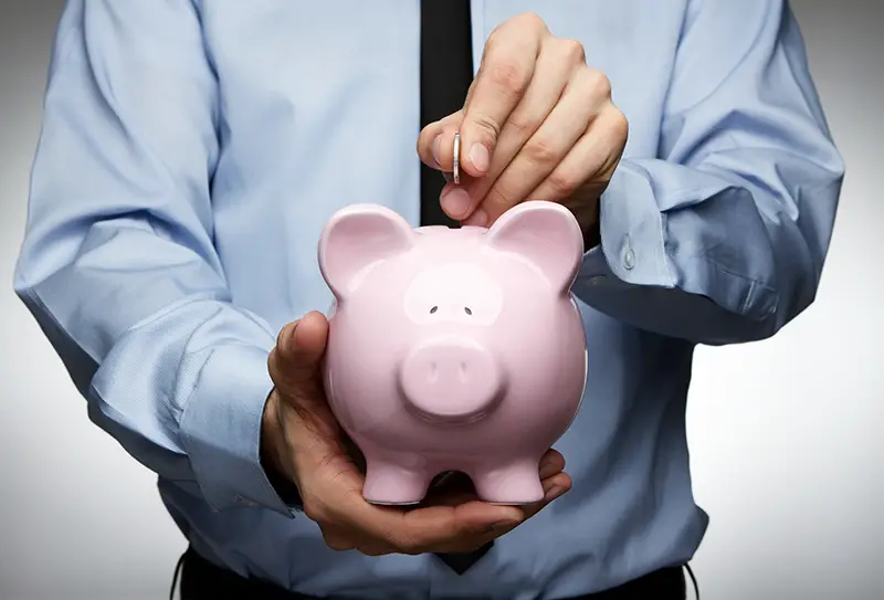 Businessman savings on piggy bank
