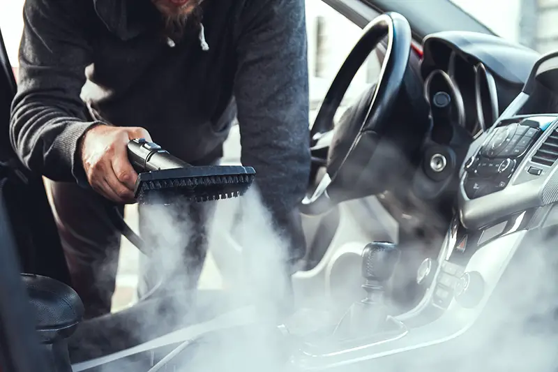 cleaning and disinfecting by steam of the car interior and a car seats with a steam cleaner