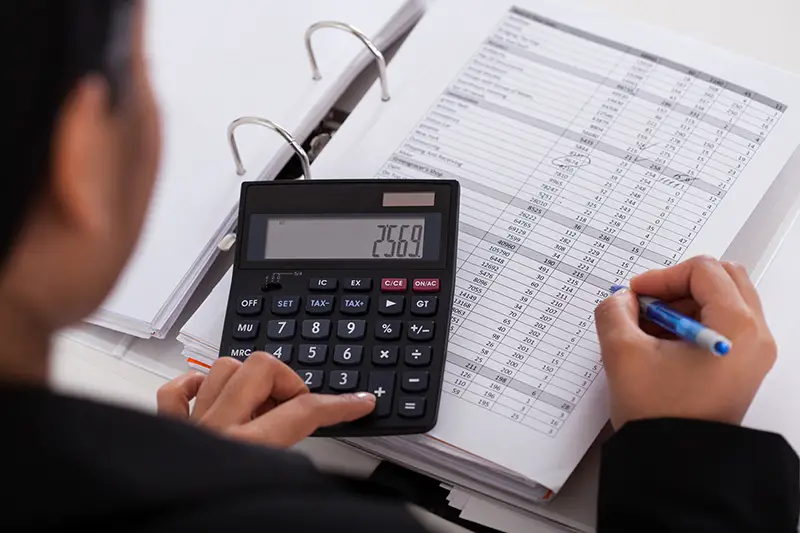 Young Businesswoman Doing Calculations In The Office