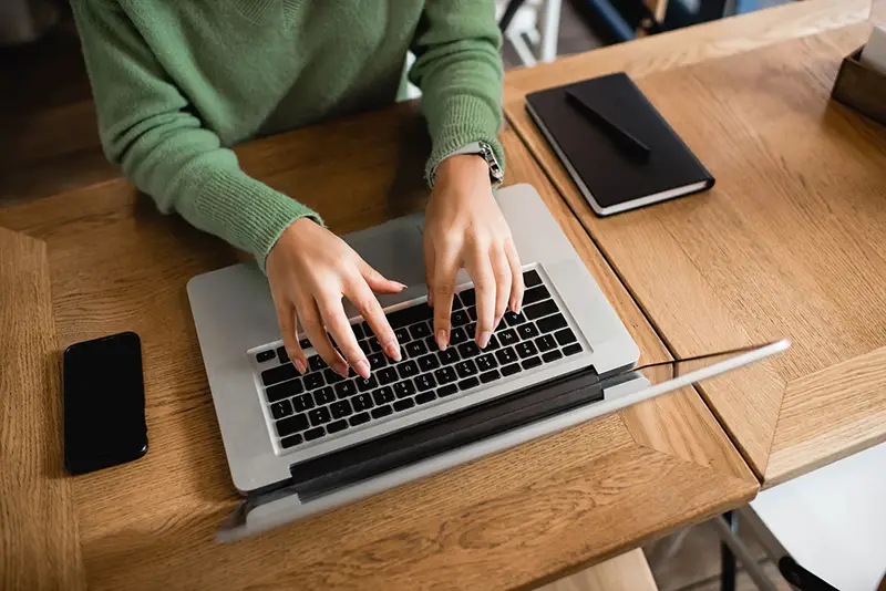 woman typing on her laptop keyboard