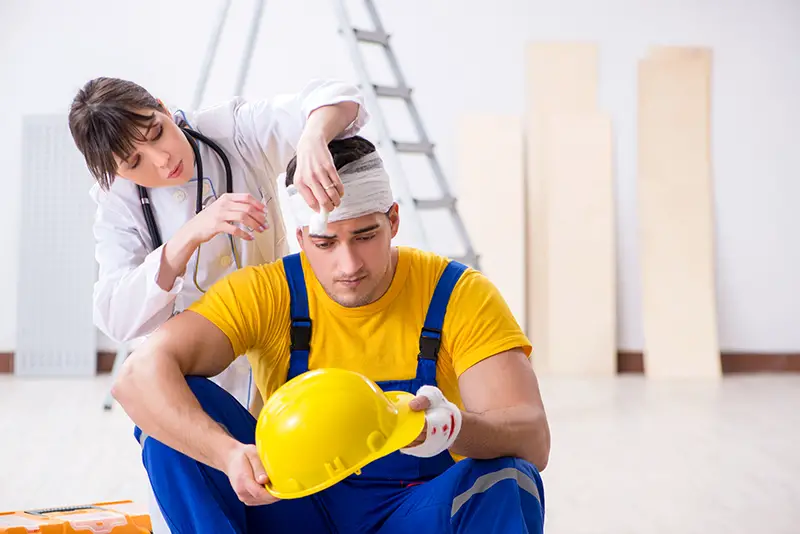 Worker with injured head and doctor