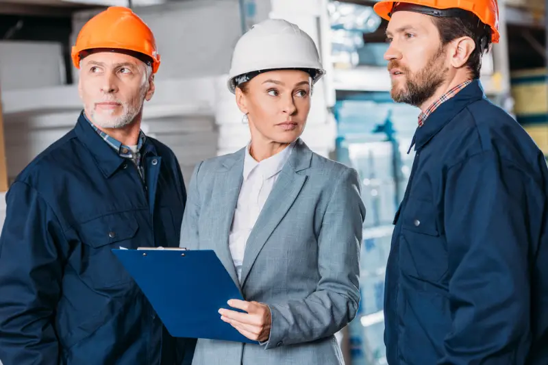 Male and female wearing work helmets in the warehouse