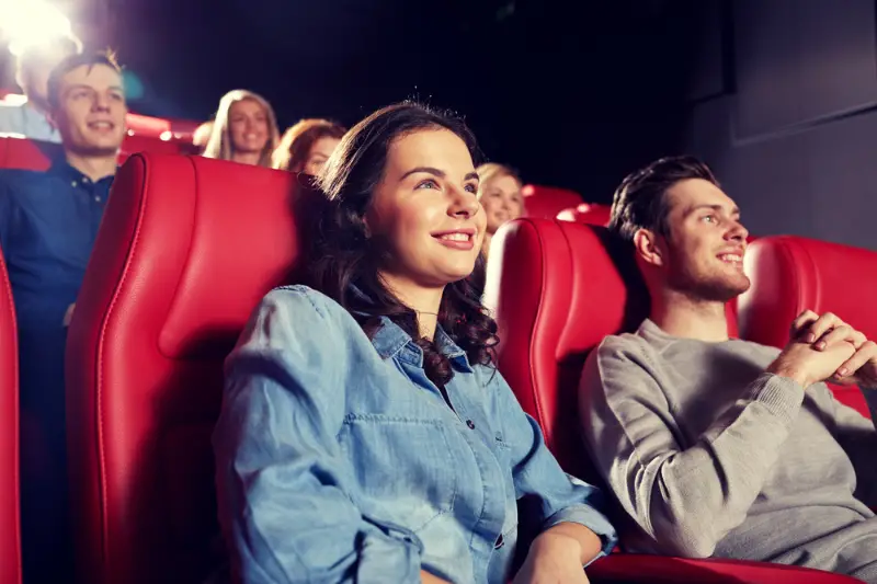 Happy friends watching movie in theater