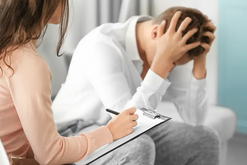 Young depressed man at doctor's office