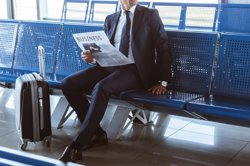 Close up of adult businessman sitting at departure
