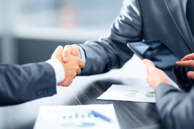 Financial Professionals shaking hands in office