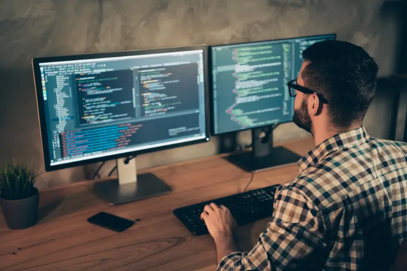 bearded guy wearing checkered shirt working on software development