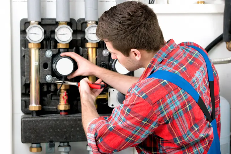 Technician servicing heating boiler