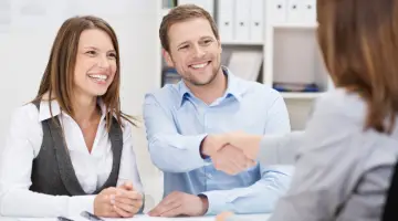 Smiling young man shaking hands with an agent
