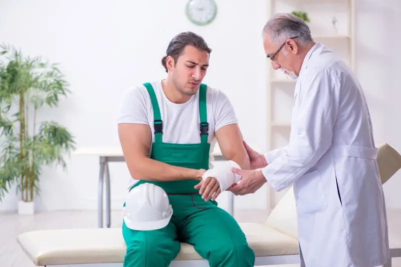 Young male contractor visiting old doctor