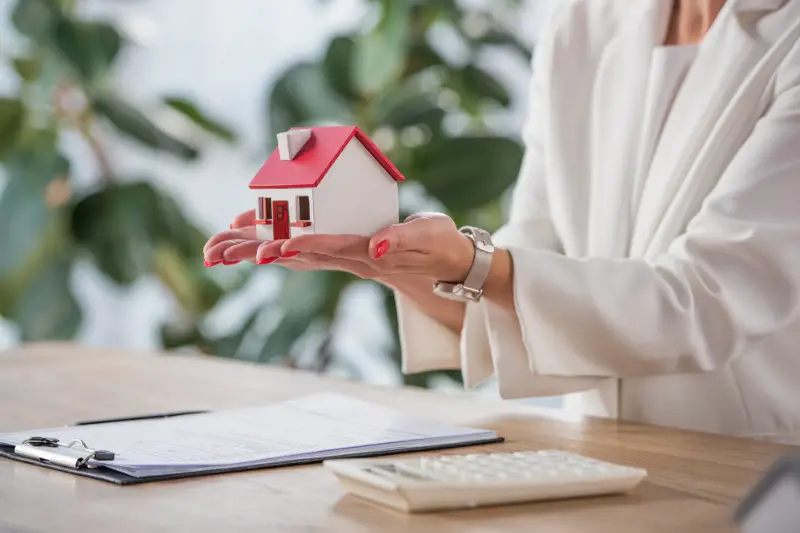 businesswoman holding house model