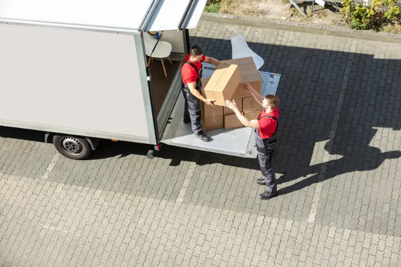 An Overhead View Of A Male Movers Unloading the cardboard boxes form from truck