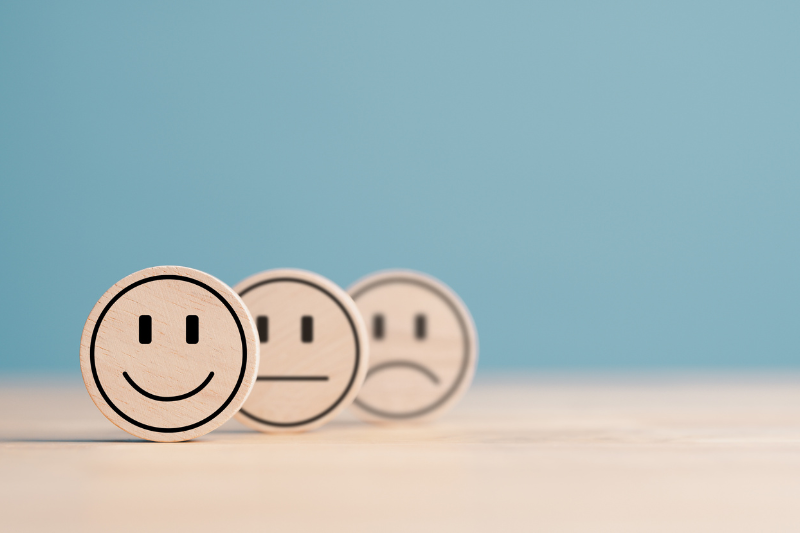 Wooden label with happy normal and sad face icons for experience survey services and products review concept.