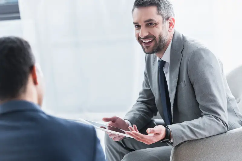 Smiling young businessman holding digital tablet