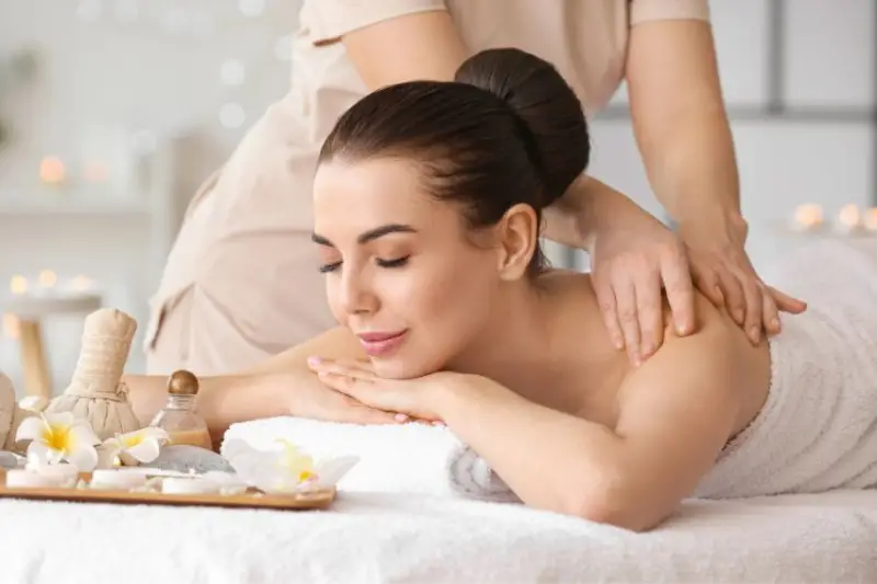 young woman receiving massage in spa salon