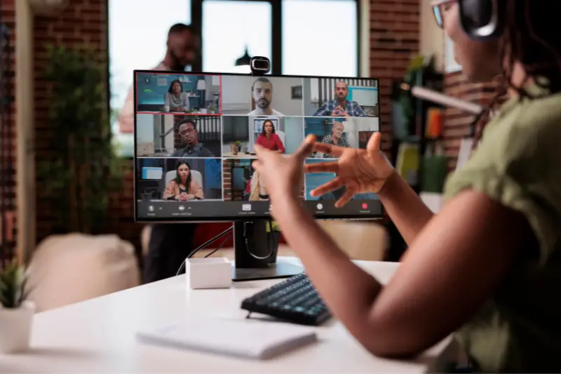 African american startup employee working from home gesturing in video conference with colleagues at desk. 