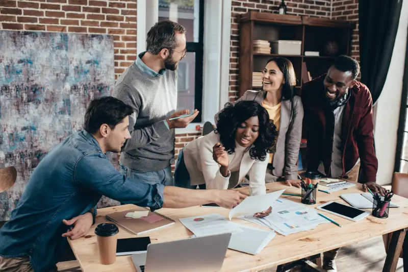 Smiling multiethnic group of co-workers having meeting in modern office