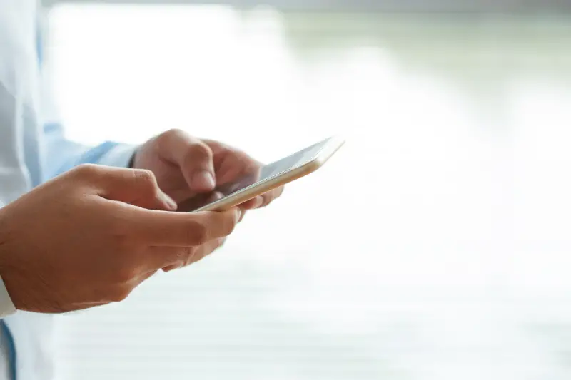 Hand of a person using mobile phone