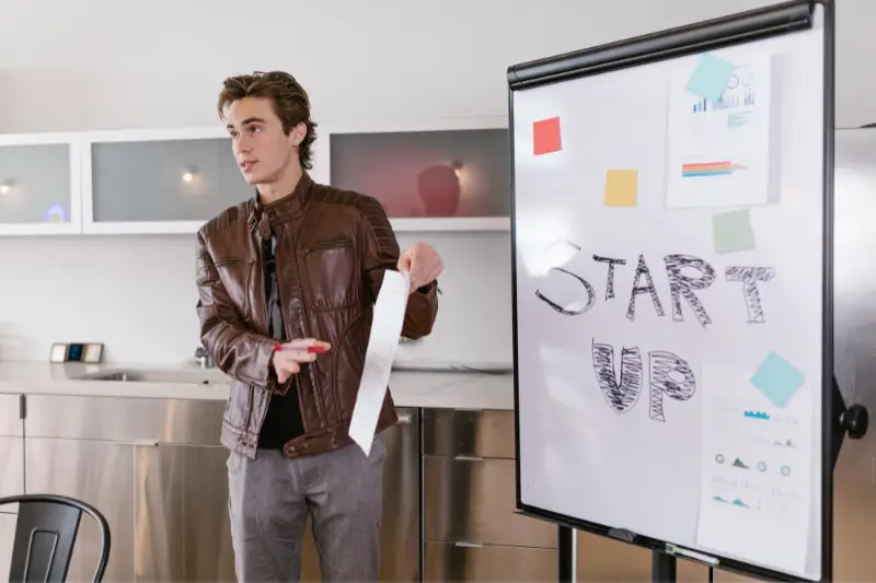 Young businessman talking near the white board
