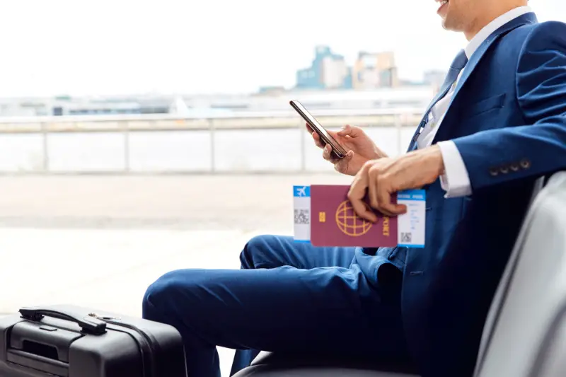 Businessman With Passport And Boarding Pass sitting airport departure lounge