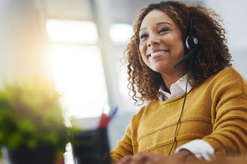 Young african woman, call center agent or listen on voip headset