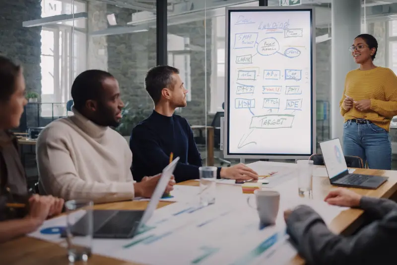 Project Manager Makes a Presentation for a Young Diverse Creative Team in Meeting Room in an Agency.