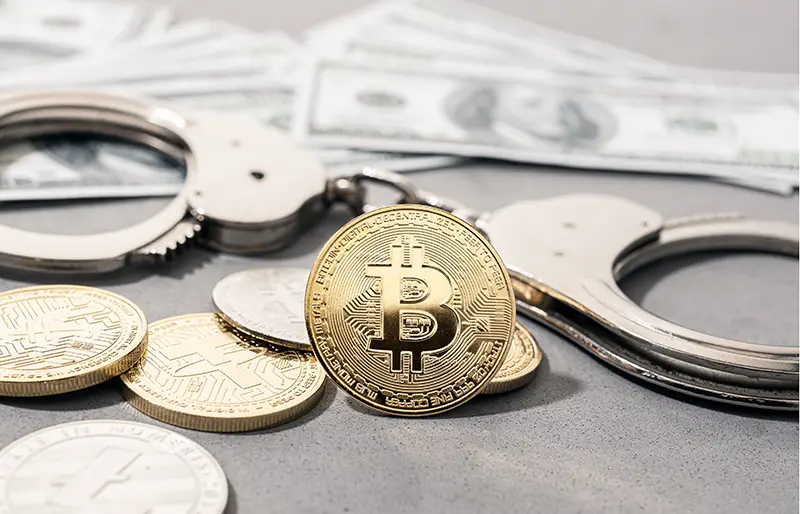 Crypto crime fraud concept. Bitcoin and crypto coins, handcuffs and US dollar banknotes