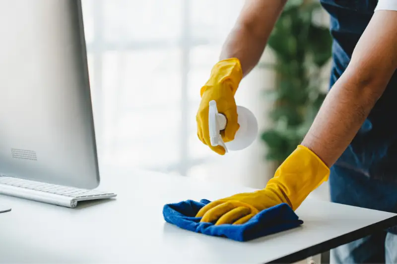 people doing cleaning are using cloths and spraying disinfectant Wipe the desk and floor in the office room