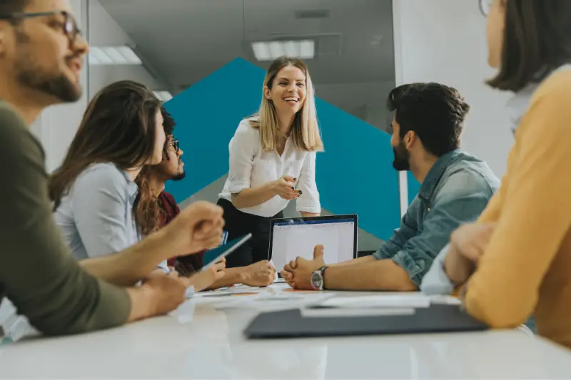 female team leader talking with mixed race group of people in the office