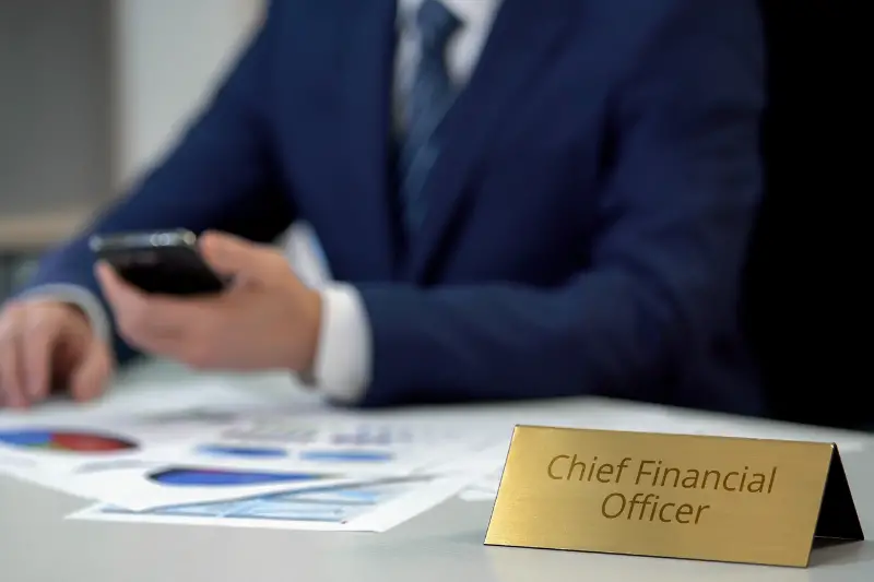 Chief financial officer checking data in annual report, using smartphone