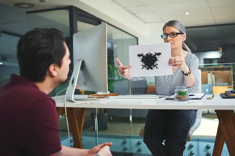Mature psychologist conducting an inkblot test to a patient