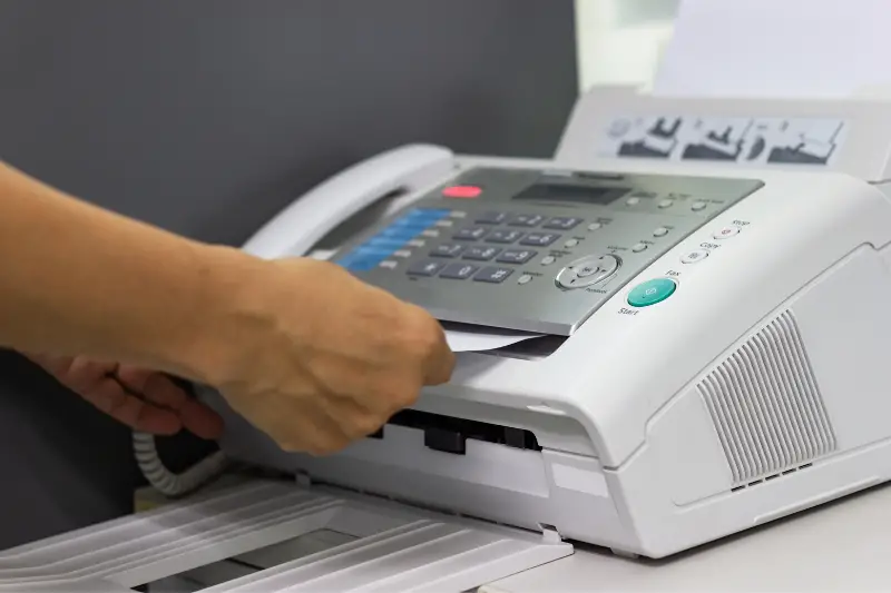 hand of man are using a fax machine in the office Business concept